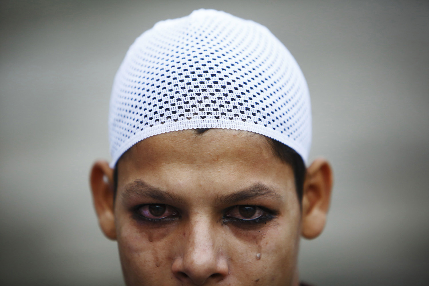 A boy tears after applying kohl to his eyelid before Eid al-Fitr mass prayers at the Kashmiri Takiya Jame mosque in Kathmandu
