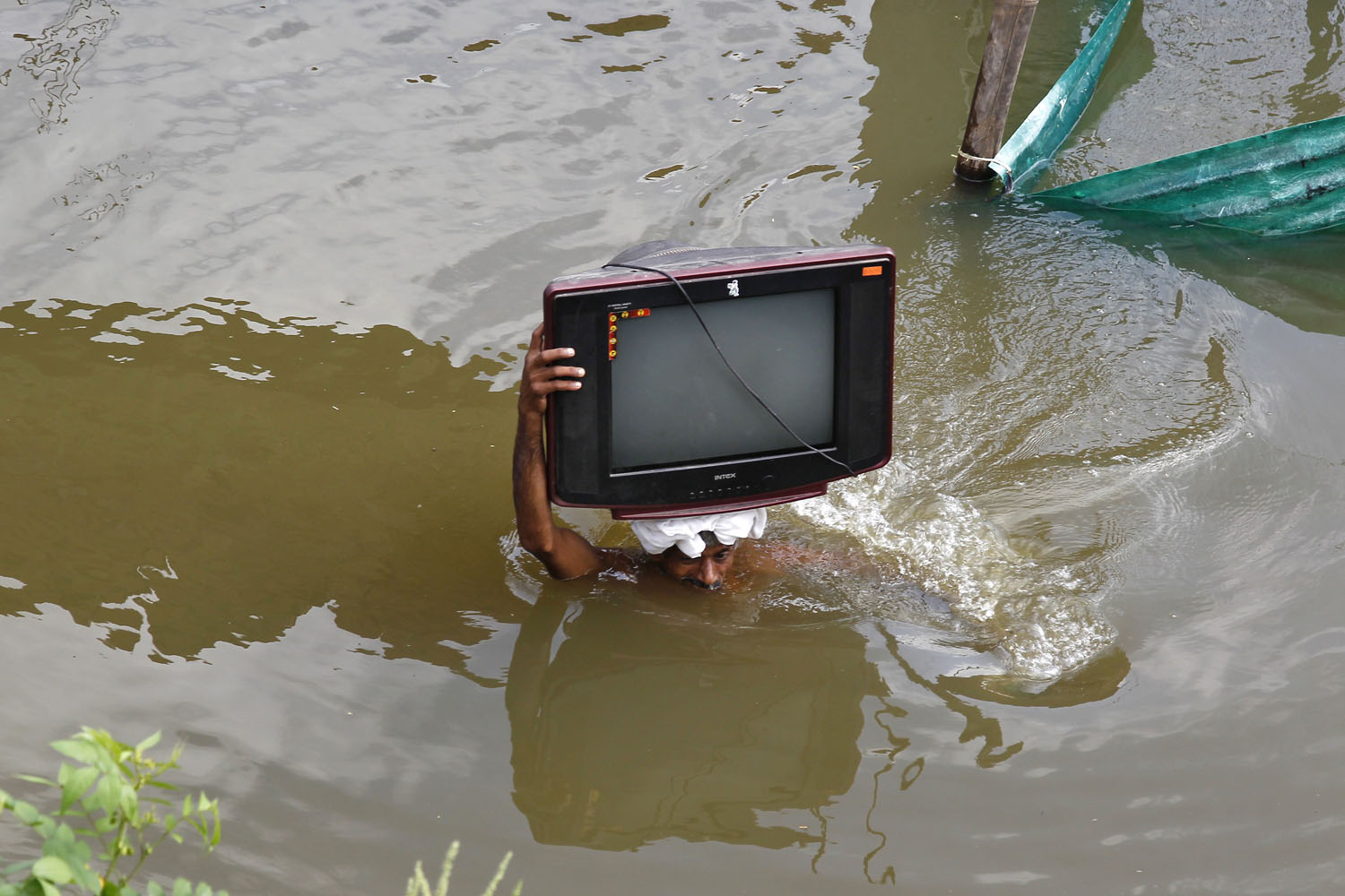 Aug. 1, 2013. A flood-affected man carries his television set to a safer place, after heavy monsoon rains caused a rise in the water levels of the river Ganges, in the northern Indian city of Allahabad.