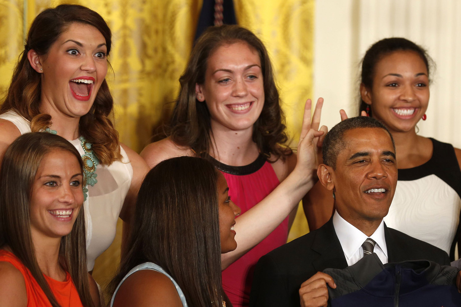 July 31, 2013. Stefanie Dolson (top left), NCAA Women's Basketball 2013 National Champion player from the University of Connecticut, puts bunny ears over U.S. President Barack Obama during a ceremony to honor the team in the East Room at the White House in Washington.