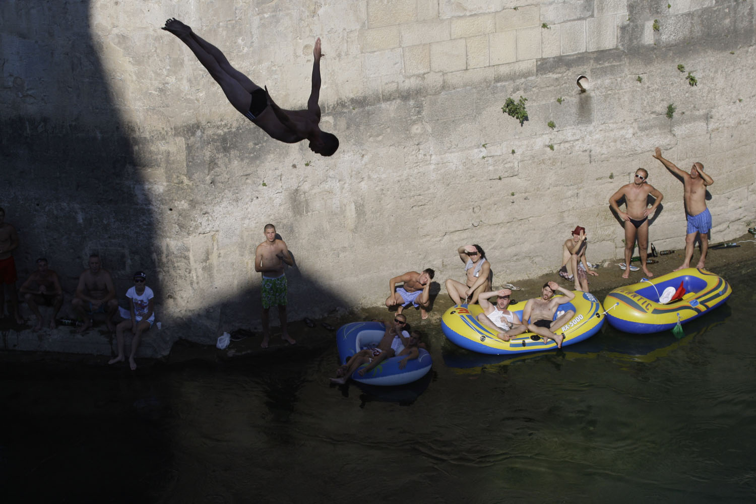 July 28, 2013. Spectators watch as a diver jumps from the Old Mostar Bridge during 447th traditional annual high diving competition, in Mostar, 140 kms south of the Bosnian capital of Sarajevo.