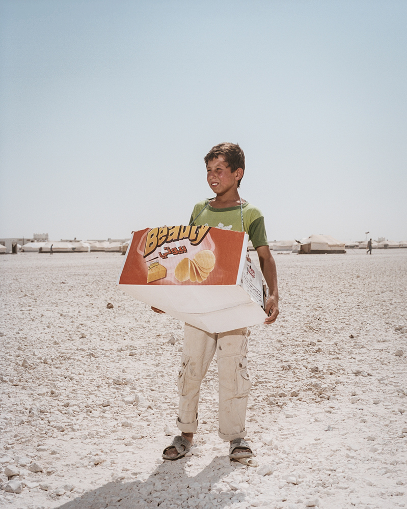 A boy named Malek Syria sells chips on the baren outskirts of Zaatari.