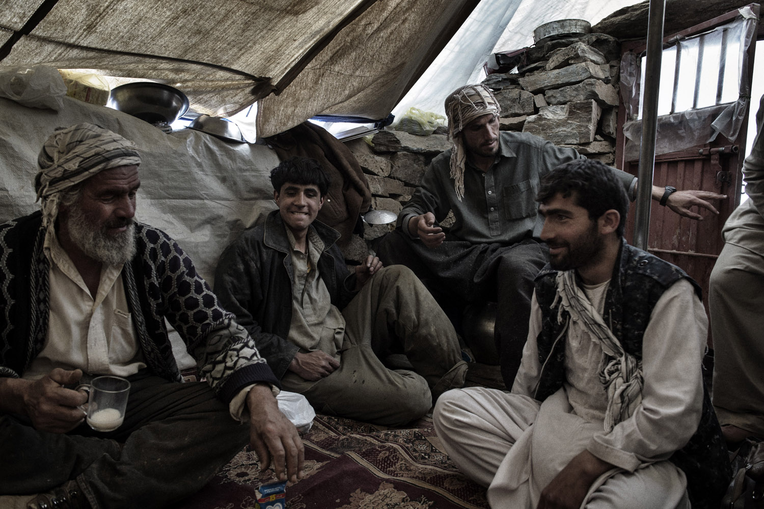 Panjshir Valley in north-central Afghanistan May 2013:A group of emerald miners take a tea break in their makeshift tent at the top of the mountain in Panjshir. Rumors of men who have made millions overnight keep the miners going.