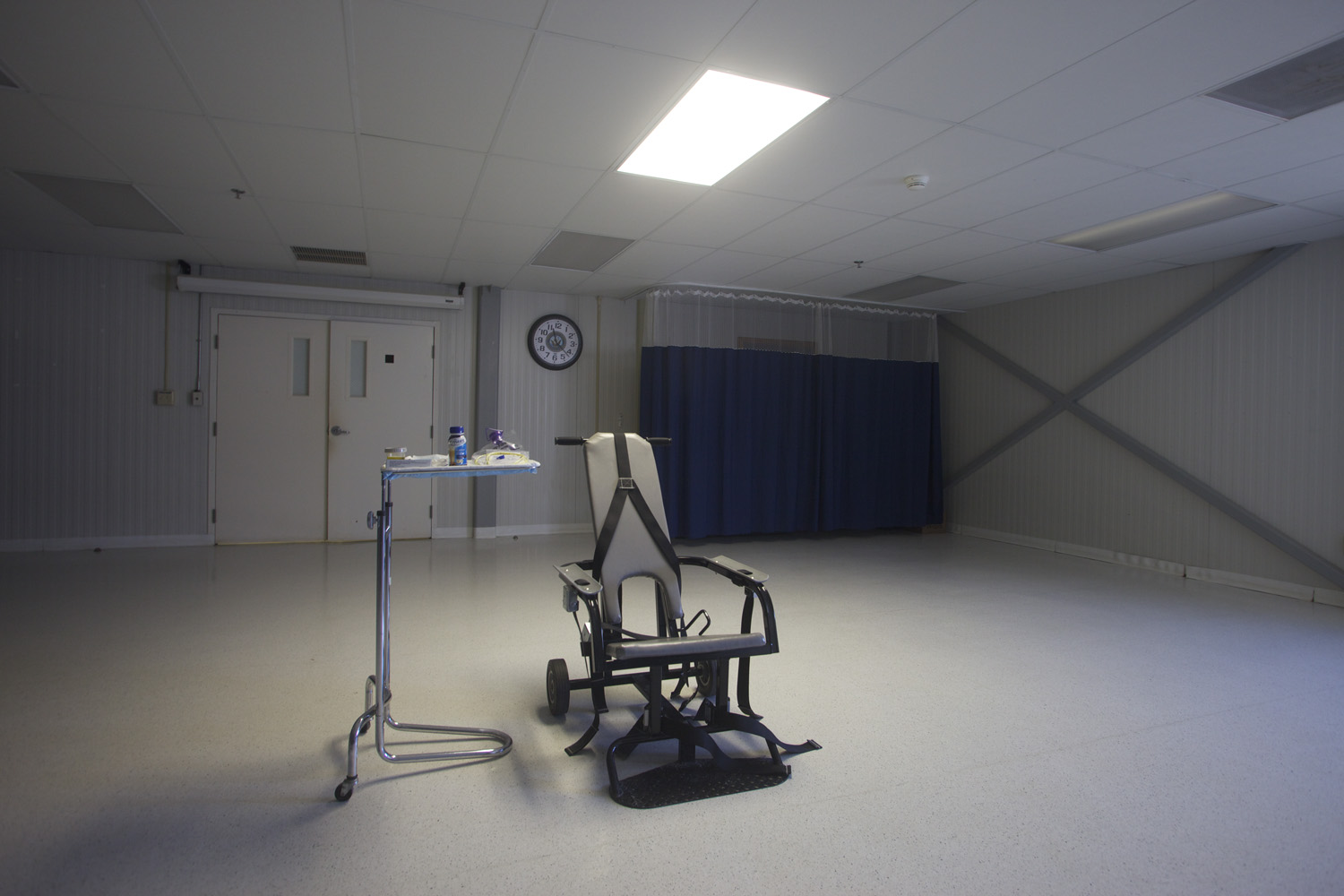 The restraining chair and forced feeding apparatus on display in an empty room of the detainee hospital.