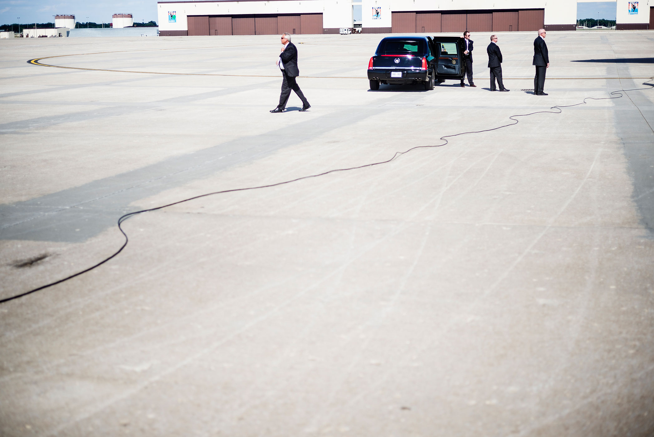 Secret Service agents wait near a car at Whiteman Air Force Base July 24, 2013 in Missouri.