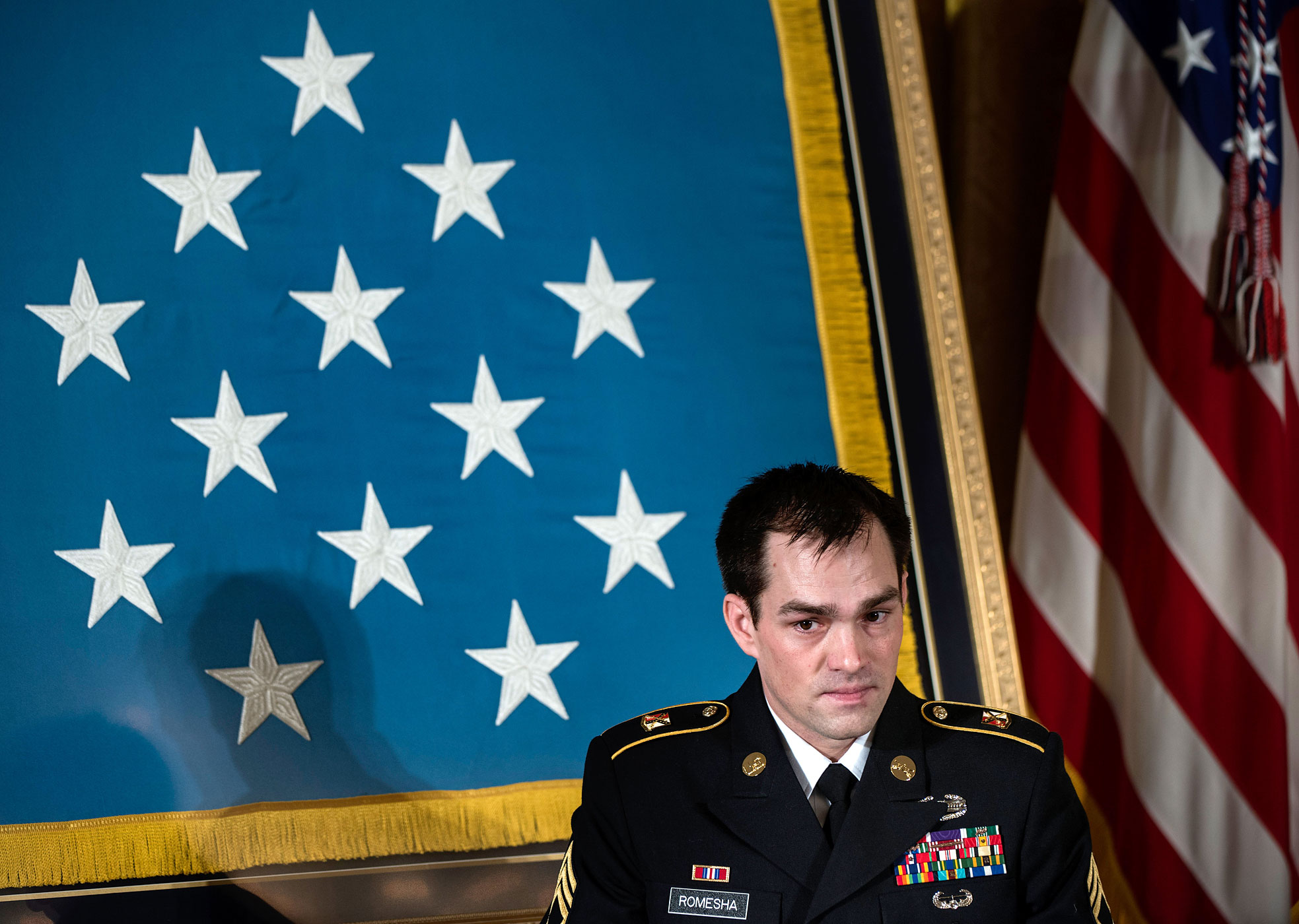 Army Staff Sargent Clinton Romesha listens during a Medal of Honor ceremony in the East Room of the White House in Washington, Feb. 11, 2013.
