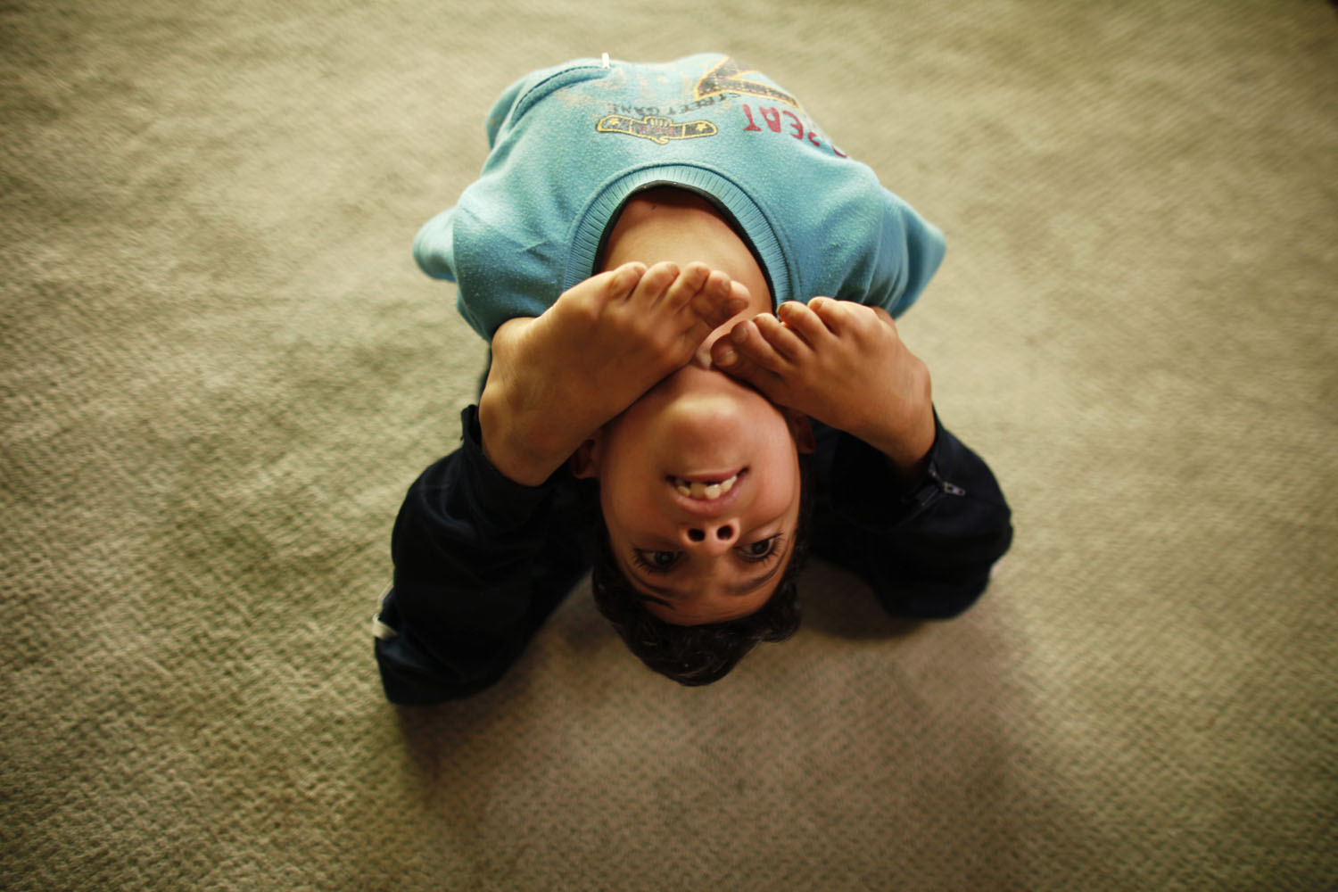 Boy stretches as he exercises at a fitness center in Sanaa