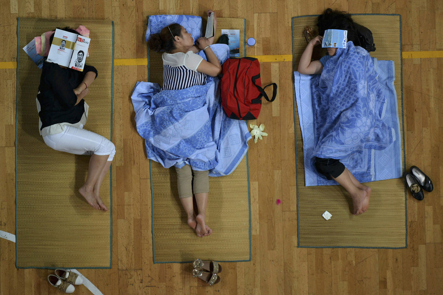 Parents of freshmen students sleep on mats laid out on the floor of a gymnasium at Huazhong Normal University in Wuhan