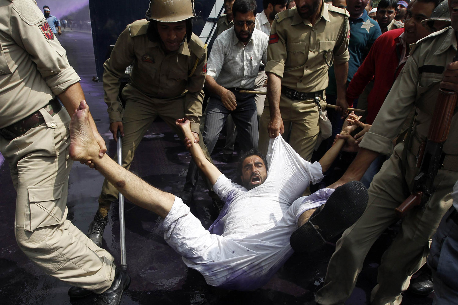 Indian police detain a government employee during a demonstration in Srinagar