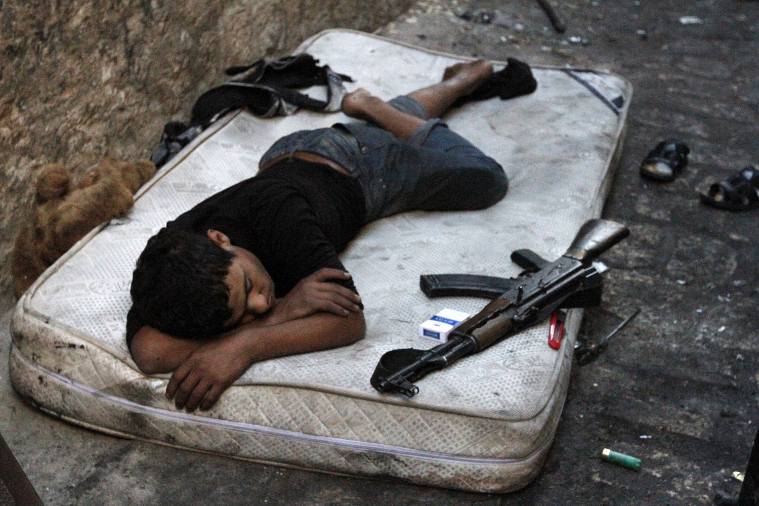 A young Free Syrian Army fighter sleeps on a mattress in the old city of Aleppo