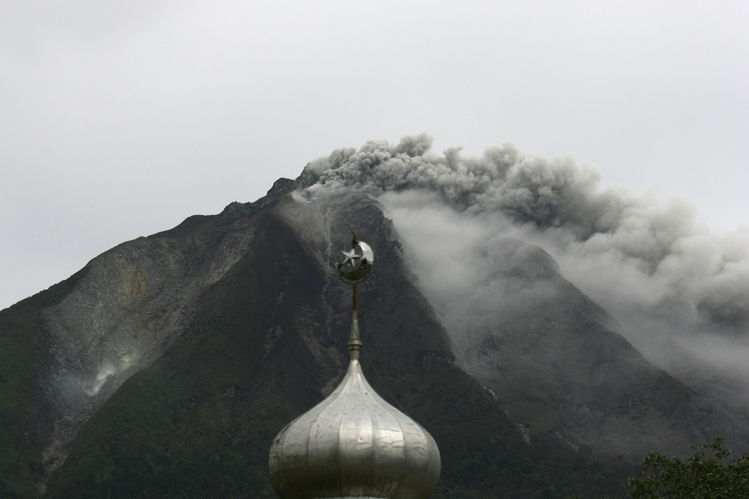 Mount Sinabung spews ash and hot lava as it erupts near a mosque in Karo district, Indonesia's north Sumatra province
