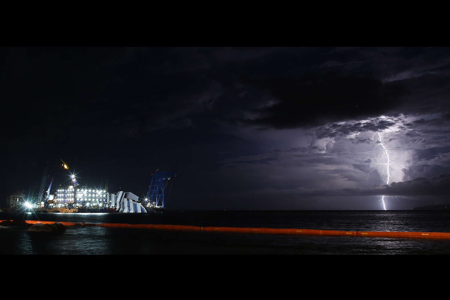 A lightning storm is pictured over the sea near the capsized cruise liner Costa Concordia, outside Giglio harbour