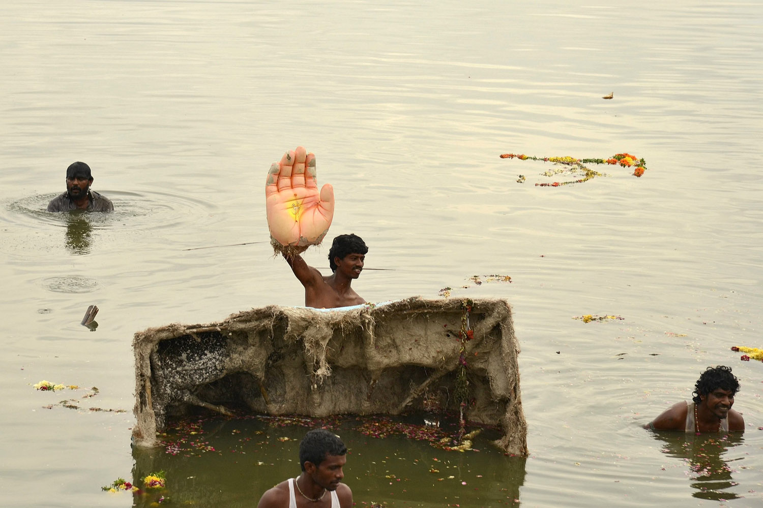 A man holds the hand of an idol of the Hindu elephant god Ganesh during idol immersion ceremony in the Hussain Sagar lake during the Ganesh Chaturthi festival in Hyderabad