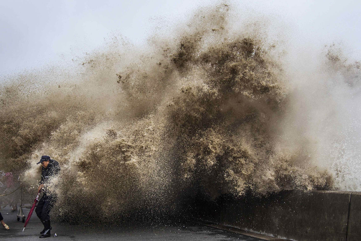 A man dodges tidal waves under the influence of Typhoon Usagi in Hangzhou