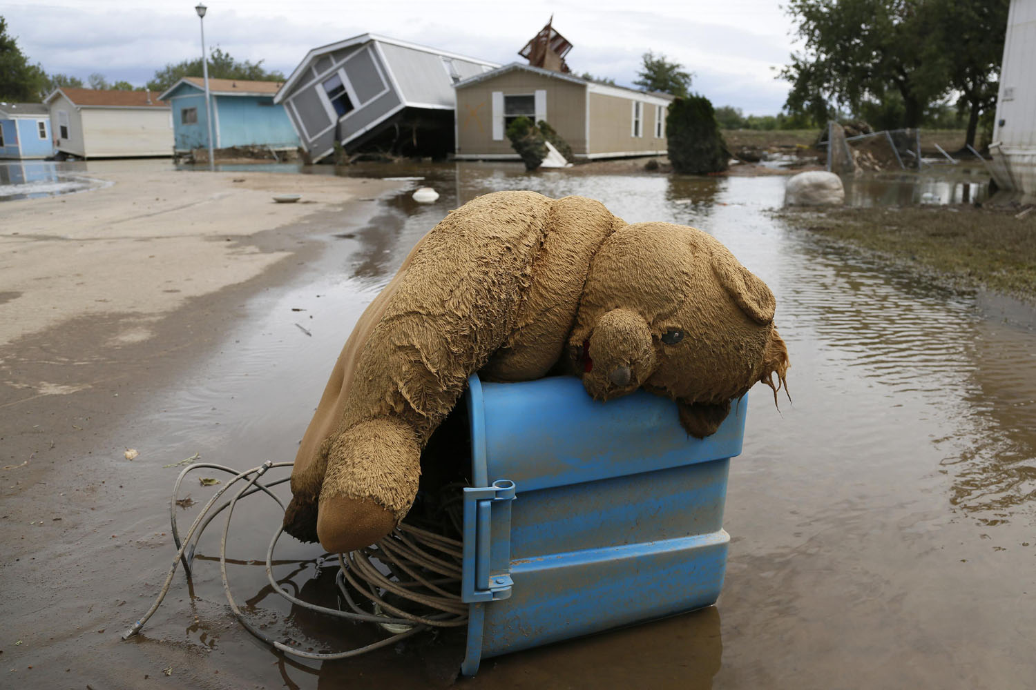 A stuffed teddy bear chair lies slumped over in the flooded Eastwood Village in Evans, Colorado