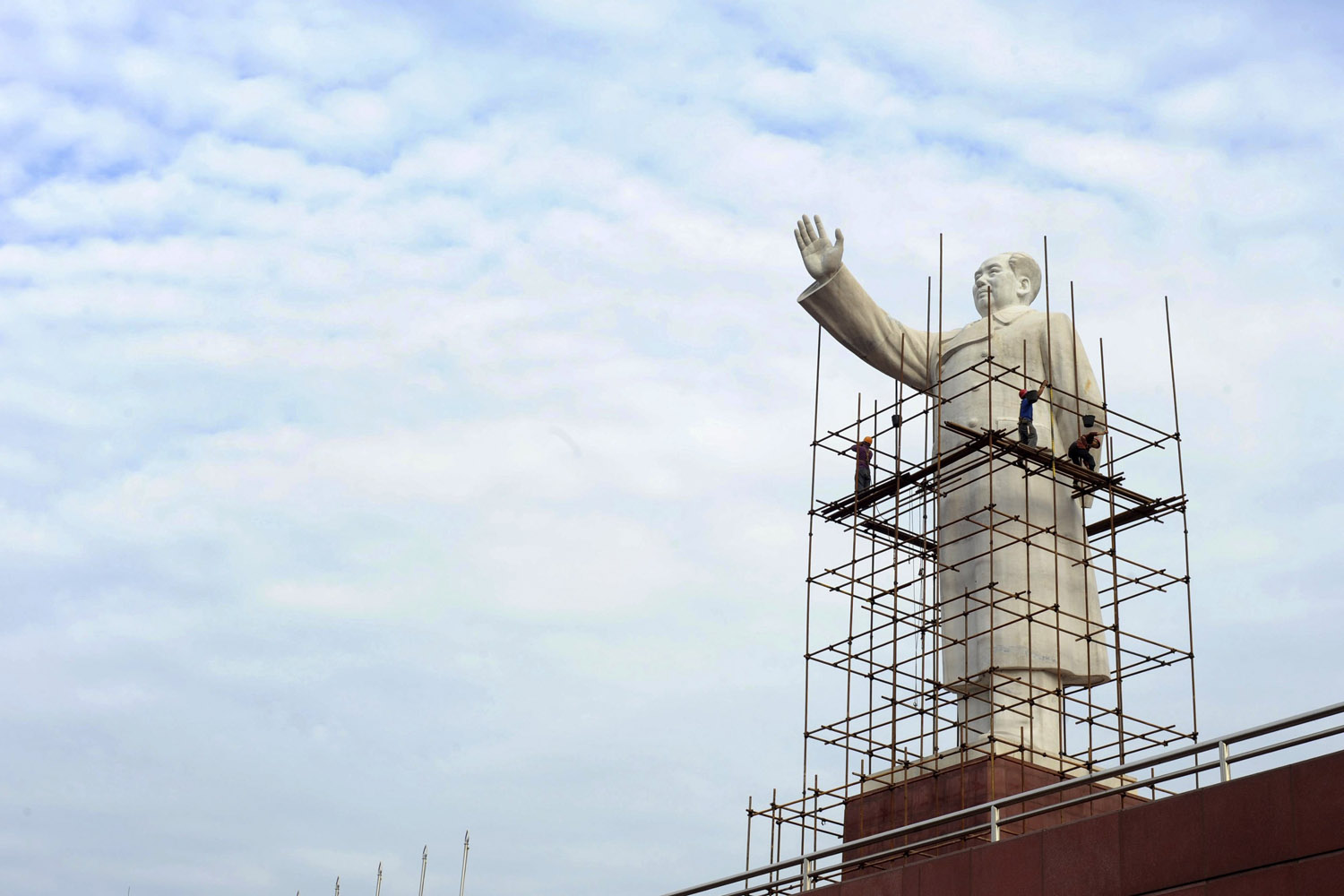 Labourers set up scaffolding to clean a statue of China's late chairman Mao Zedong for the upcoming Chinese National Day at Tianfu Square in Chengdu, Sichuan province