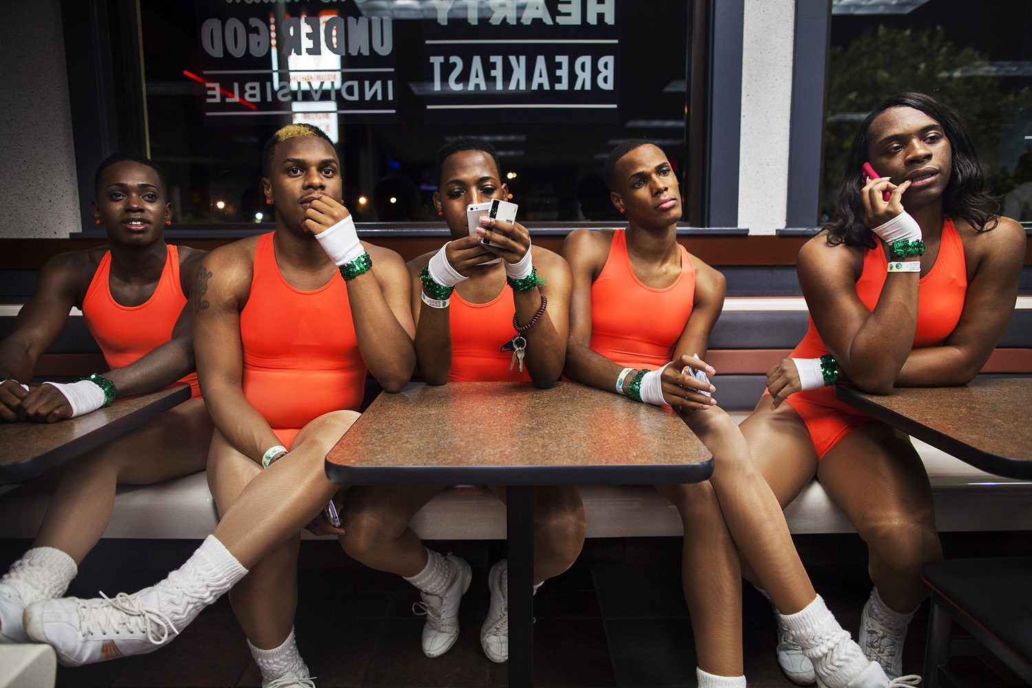 (L-R) KJ, Kentrell, Jerel, Adrian and Tim/Tamara sit in a fast food restaurant to regroup before driving back to Mobile after a night out at a gay club in Pensacola. The group frequents gay clubs in Mobile, and also travels to clubs in Pensecola. They rarely drink alcohol, often dress in matching uniforms, and use nights out at the club to practice their routines. They see clubbing as a means for self-promotion and an opportunity to perform and dance in front of audiences. The Prancing Elites are a group of young, gay, black men who practice J-Sette, a form of dance birthed at Historically Black Colleges that is characterized by sharp, cheerleading-style movements and hip-hop performed to an eight-count beat. Traditionally, men cannot join college dance teams, so young gay black men have been forming their own J-Sette "lines," organizing competitions, and creating their own outlets to practice this type of dance.