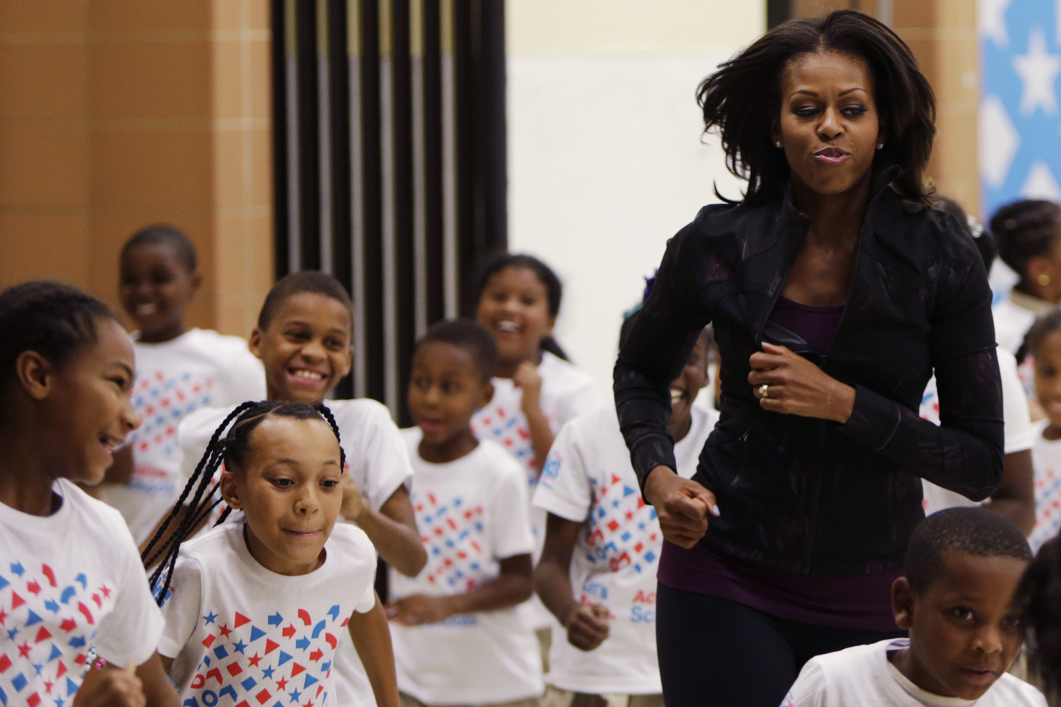 U.S. First Lady Obama jogs with children at a back-to-school event in Washington