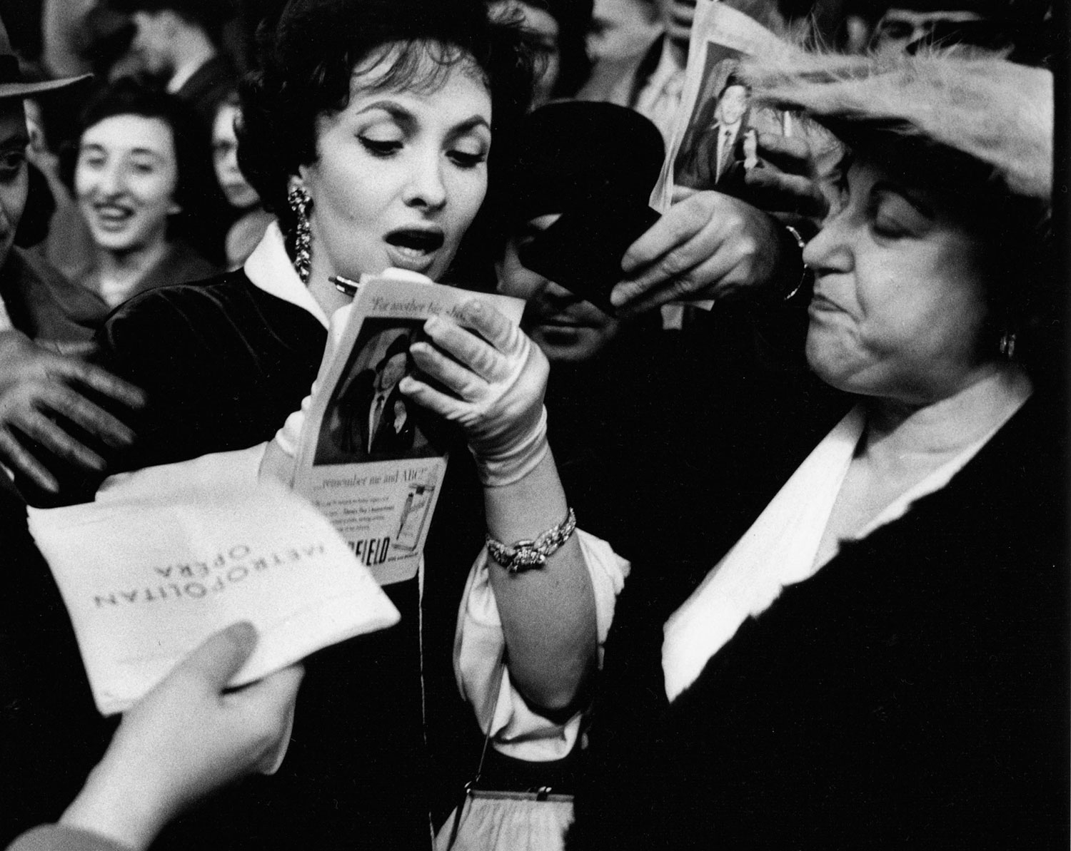 Gina Lollobrigida signs autographs in front of New York's old Metropolitan Opera House, 1958.