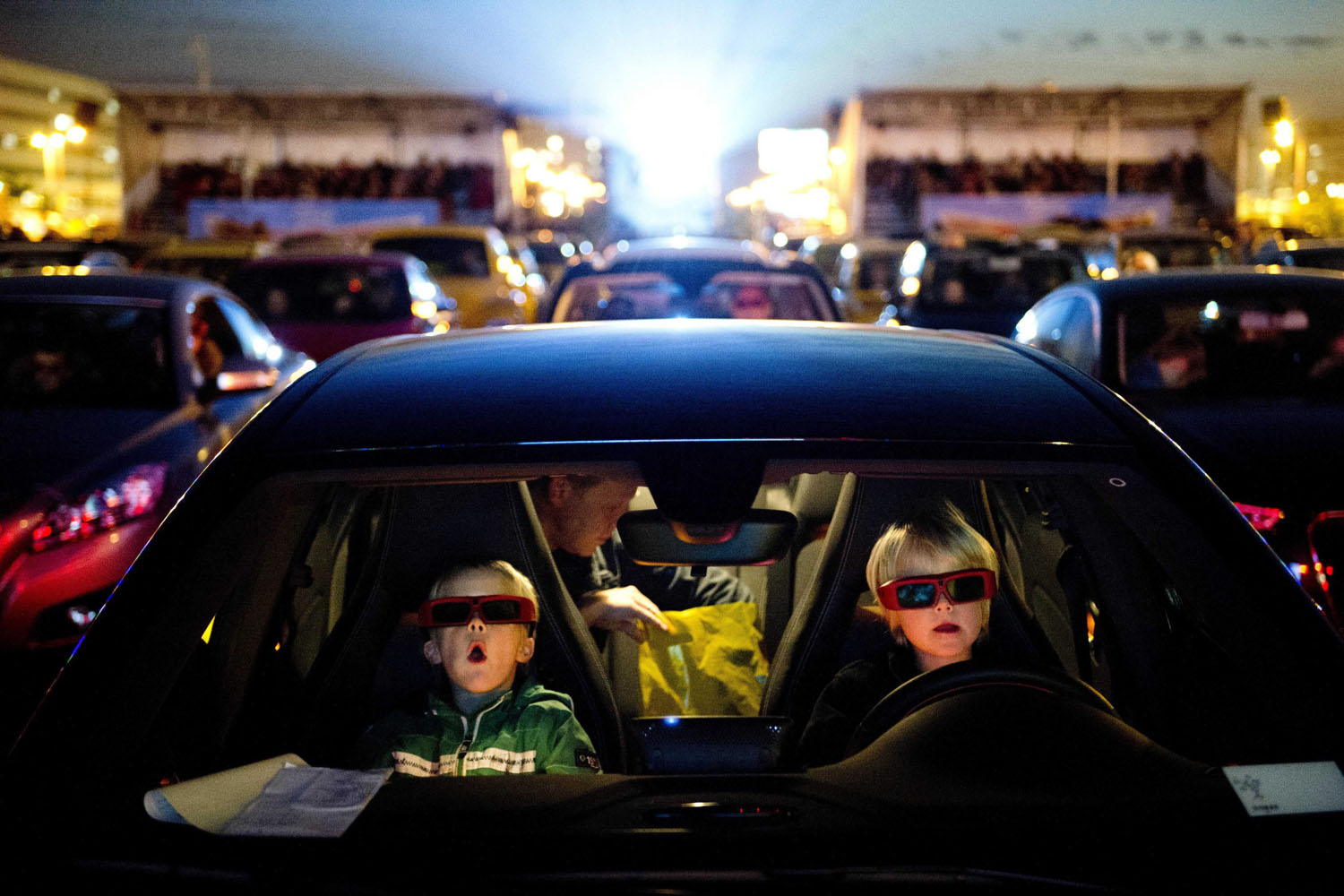 Sept. 27, 2013. Young visitors wearing 3D glasses sit in their car and watch the Disney movie 'Planes' at the drive-in movie theater on the parking lot of Amsterdam Airport Schiphol, The Netherlands.