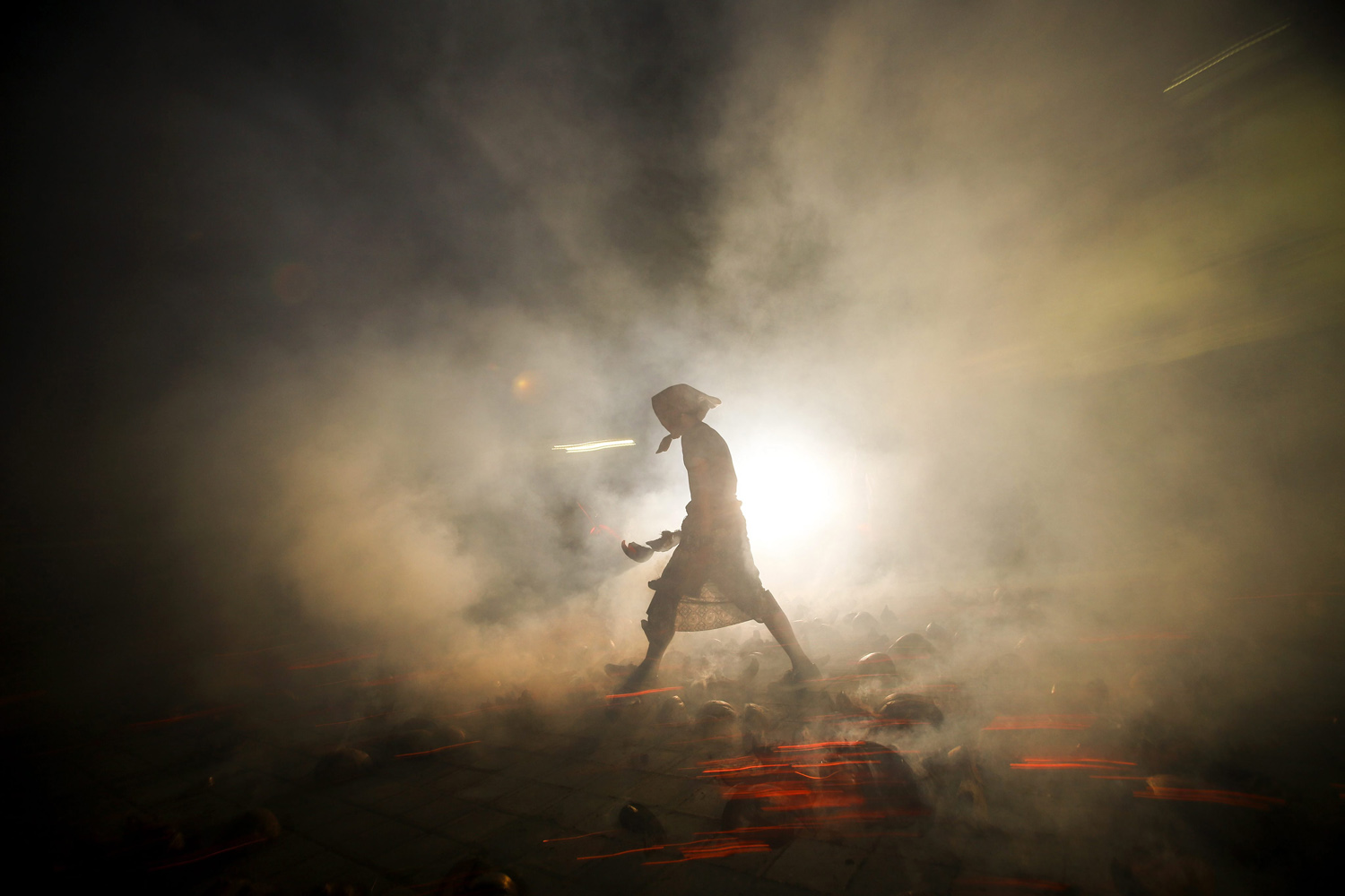 Oct. 19, 2013. A Balinese man walks among the blazing coconut husks during a sacred ritual called 'Mesabatan Api' or fire fight at a temple in Tuban, Bali, Indonesia.