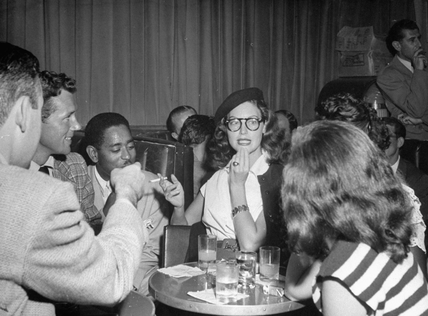 Merry actress Ava Gardner, a bop fan, dons beret and specs and pretends to wear goatee at Billy Berg's Hollywood nightclub as Dizzy (left) grins.