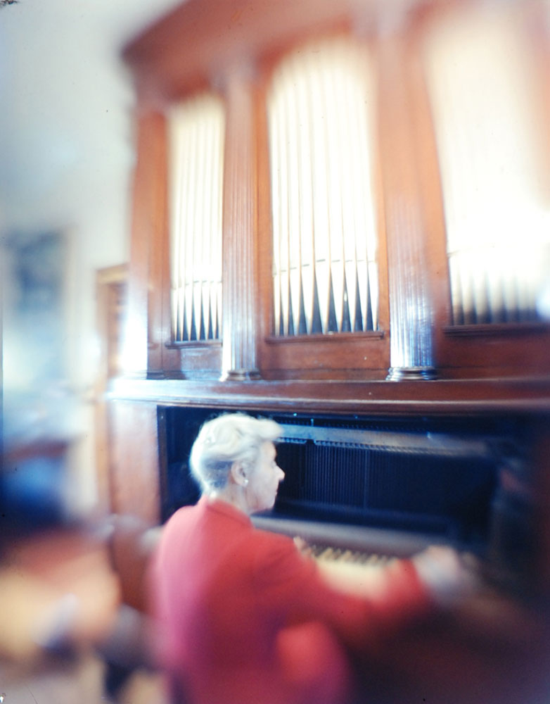 Mrs. Theodore Douglas Robinson, Harriet Cruger's great-grandniece, plays a piano in the reportedly haunted house.