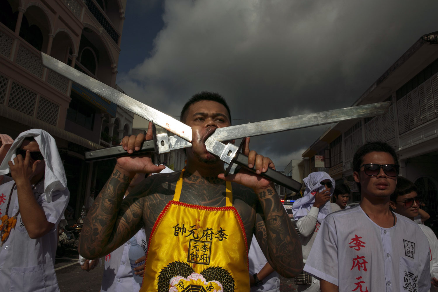 Vegetarian festival devotees parade through the streets of downtown Phuket, Thailand. Participants in the festival pierce their bodies to shift evil spirits from others onto themselves and bring good luck to the community.