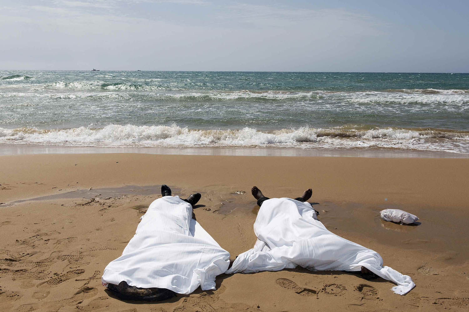 Sept. 30, 2013. Bodies of migrants who drowned lie on the beach in the Sicilian village of Sampieri.