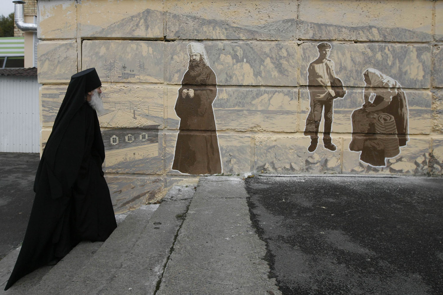 Sept. 30, 2013. Orthodox monk Father Ioakim, 74, looks at a street graffiti, which displays Siberian characters of the 19th century including an Russian Orthodox monk, in Divnogorsk town outside Russia's Siberian city of Krasnoyarsk.