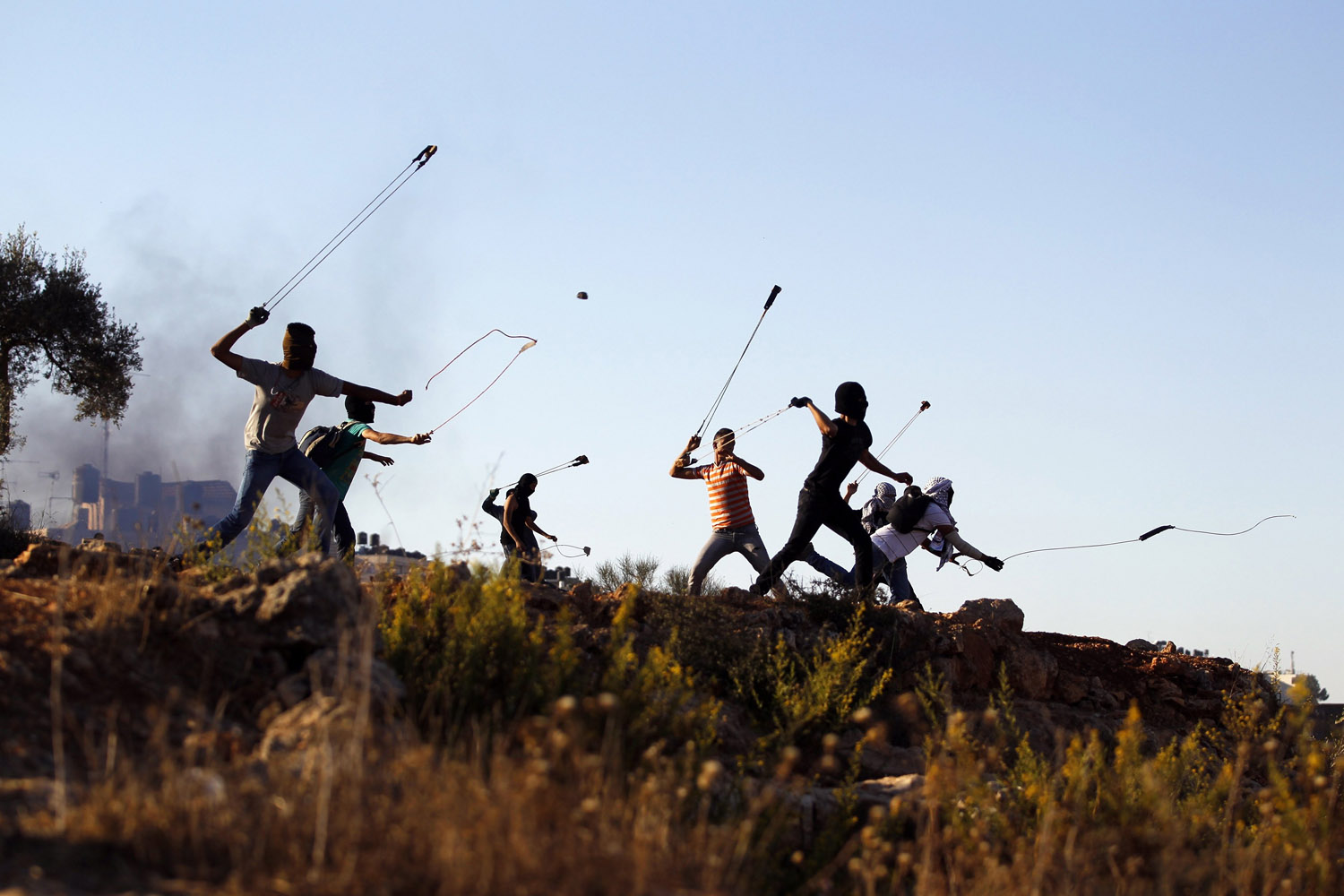 Palestinian protesters hurl rocks at Israeli soldiers during clashes in Betunia, near the West Bank city of Ramallah