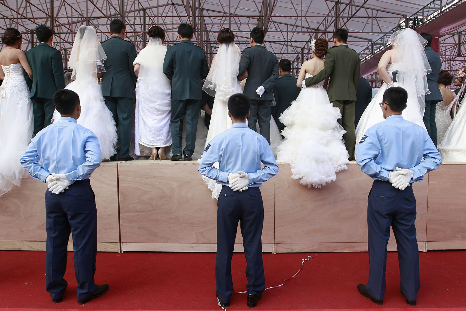 Soldiers guard a platform to prevent it from falling apart while newlyweds have their group photo taken, during a military mass wedding ceremony in Taipei