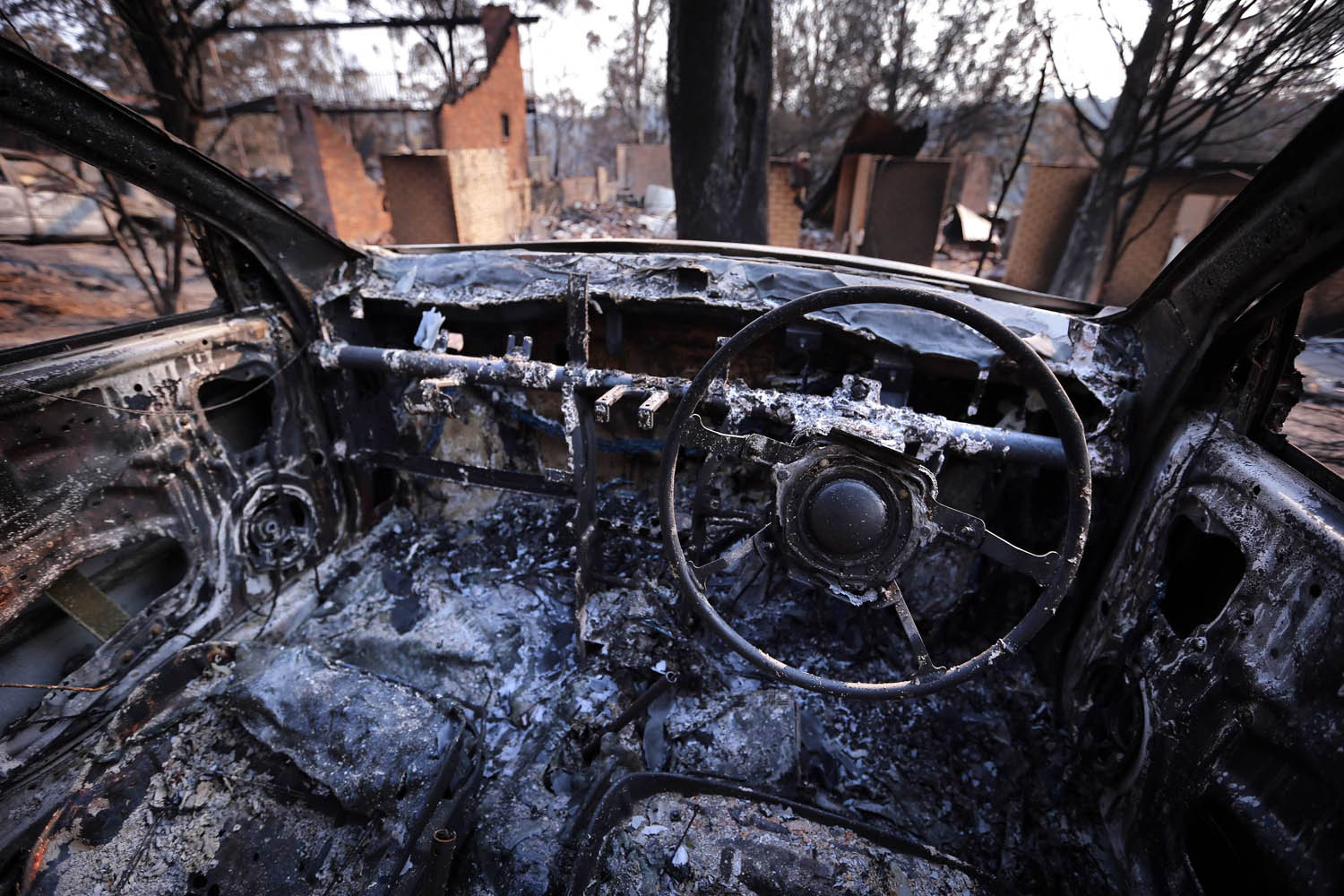 Burnt houses can be seen from inside a burnt-out car after they were destroyed by a bushfire in the Blue Mountains suburb of Winmalee