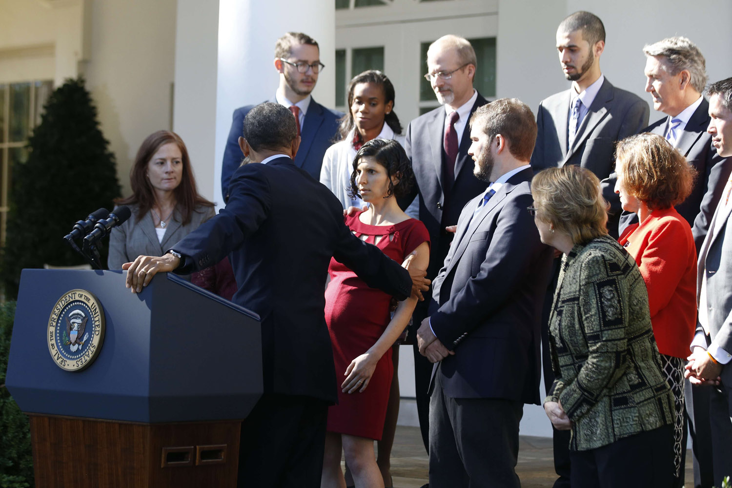 Oct. 21, 2013. U.S. President Barack Obama (2ndL) reaches out to help Affordable Care Act beneficiary Karmel Allison (C), who began to faint during the president's speech about healthcare from the Rose Garden of the White House in Washington.