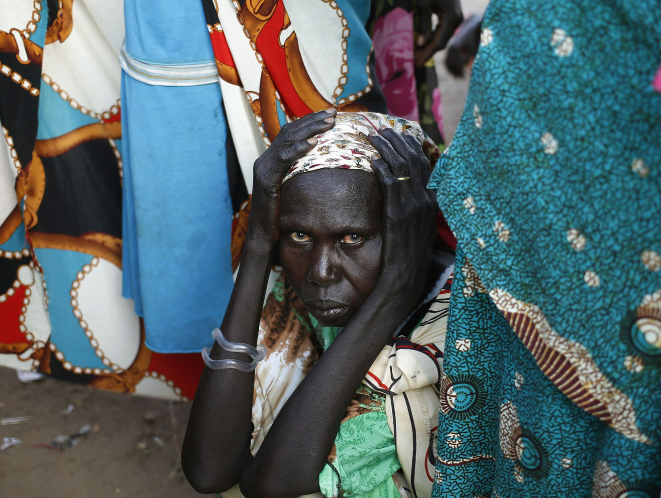 A women waits to vote in front of a polling station located in a school during a referendum in the town of Abyei
