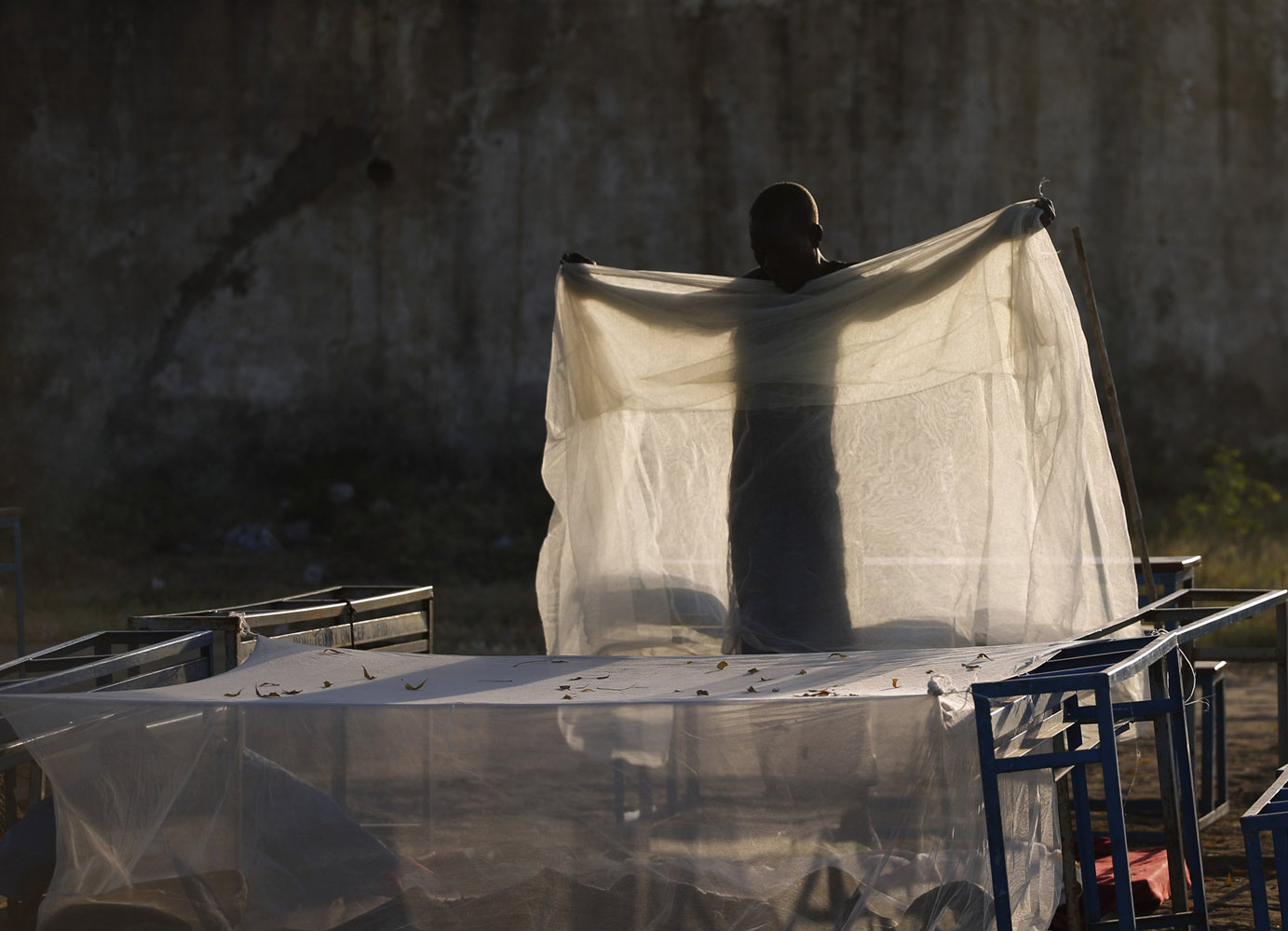 A man collects his mosquito net near a polling station located in a school during a referendum in the town of Abyei