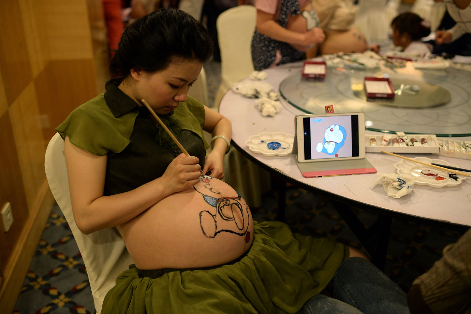Oct. 27, 2013. A pregnant woman paints her belly during a contest organized by a maternity hospital in Chongqing, China.