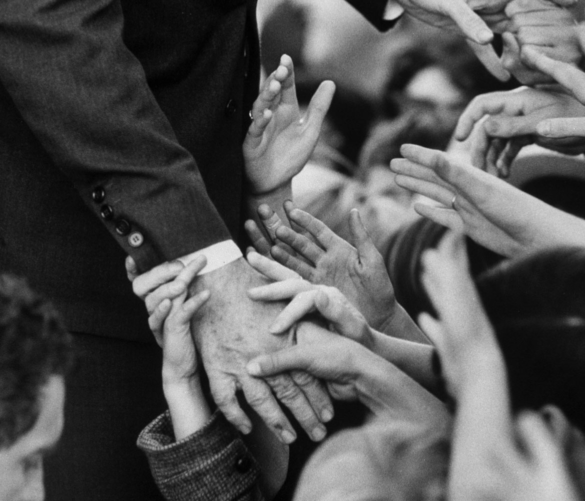 Sen. Robert F. Kennedy shaking hands with admirers while campaigning.