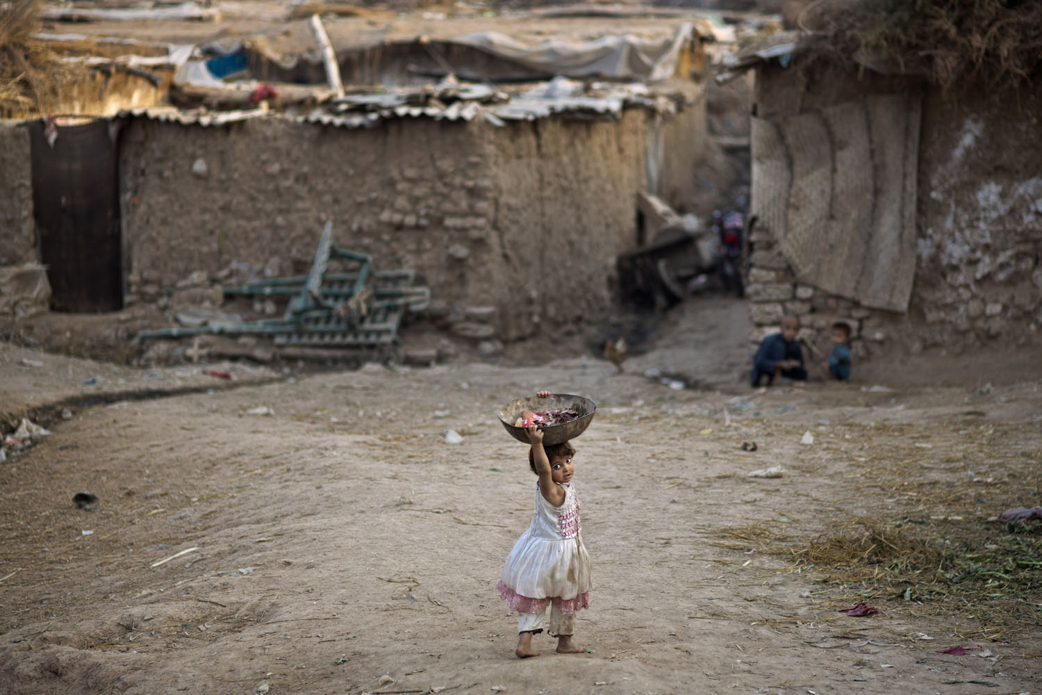 Oct. 23, 2013. An Afghan refugee child looks behind her while walking back to her home in a poor neighborhood on the outskirts of Islamabad, Pakistan.