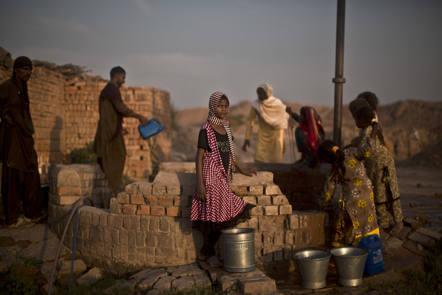 Oct. 22, 2013. Pakistani women and children, collect water from a well on the outskirts of Islamabad, Pakistan.