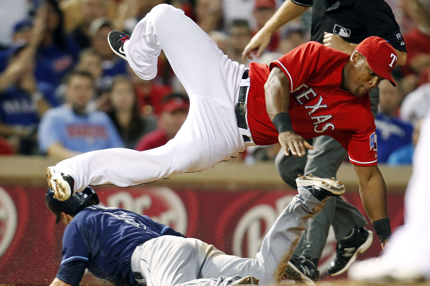 Sept. 30, 2013. Tampa Bay Rays' Sam Fuld, left, steals third base as Texas Rangers' Adrian Beltre dives for a wild throw by Tanner Scheppers during the ninth inning of an American League wild-card tiebreaker baseball game in Arlington, Texas.