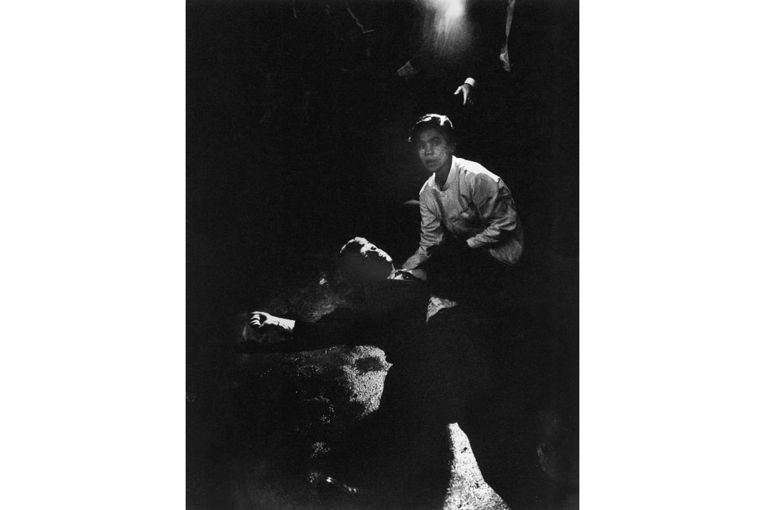 June 6, 1968.  Rigid, semiconscious, his face an ashen mask, Senator Kennedy lies in a pool of his own blood on the concrete floor, a bullet deep in his brain and another in his neck. Juan Romero, a busboy whose hand Kennedy had shaken before the shots, tried to comfort him.  - Original caption from LIFE Magazine