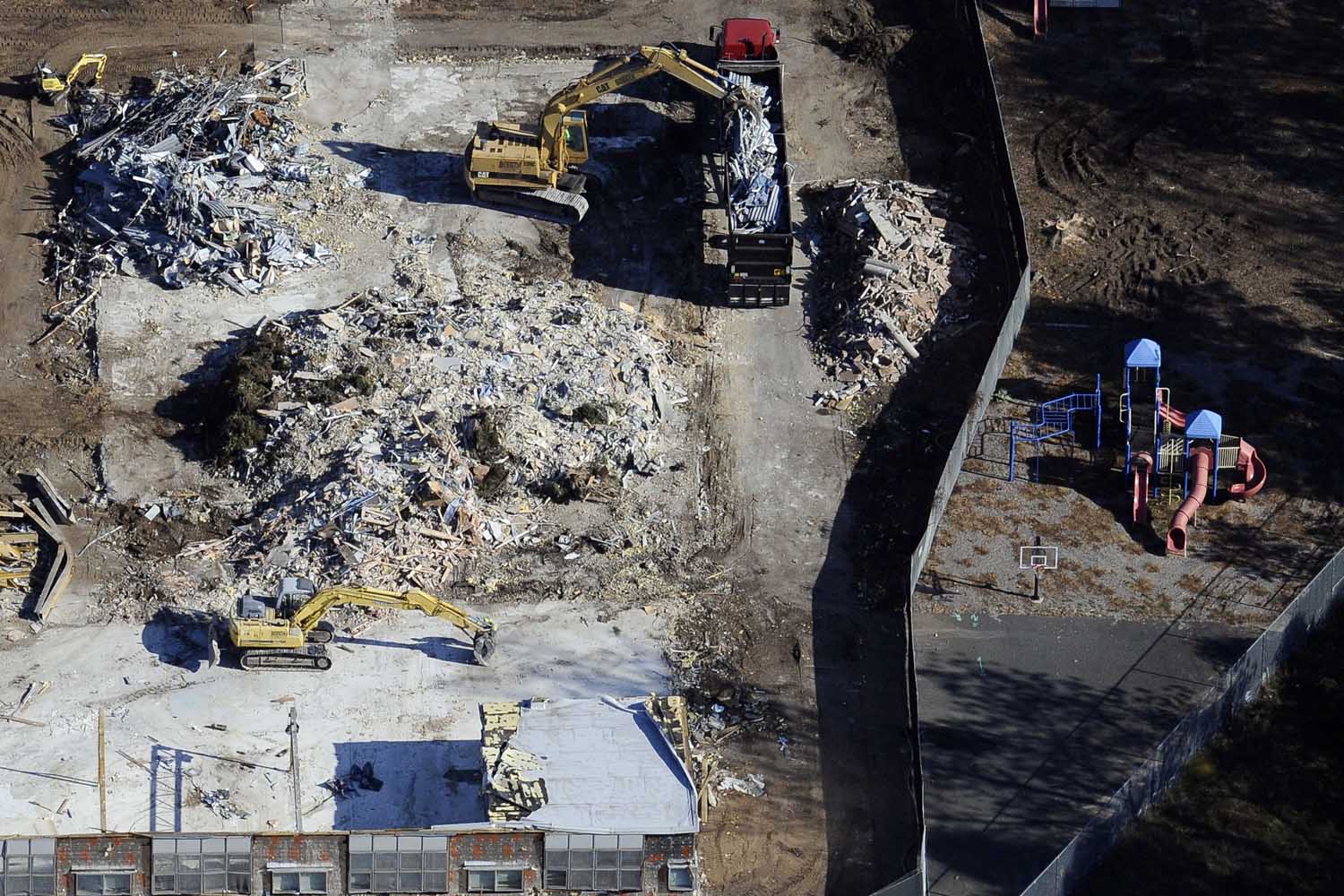 Oct. 28, 2013. Workers use backhoes to dig through the rubble as the demolition of Sandy Hook Elementary School continues in Newtown, Conn.