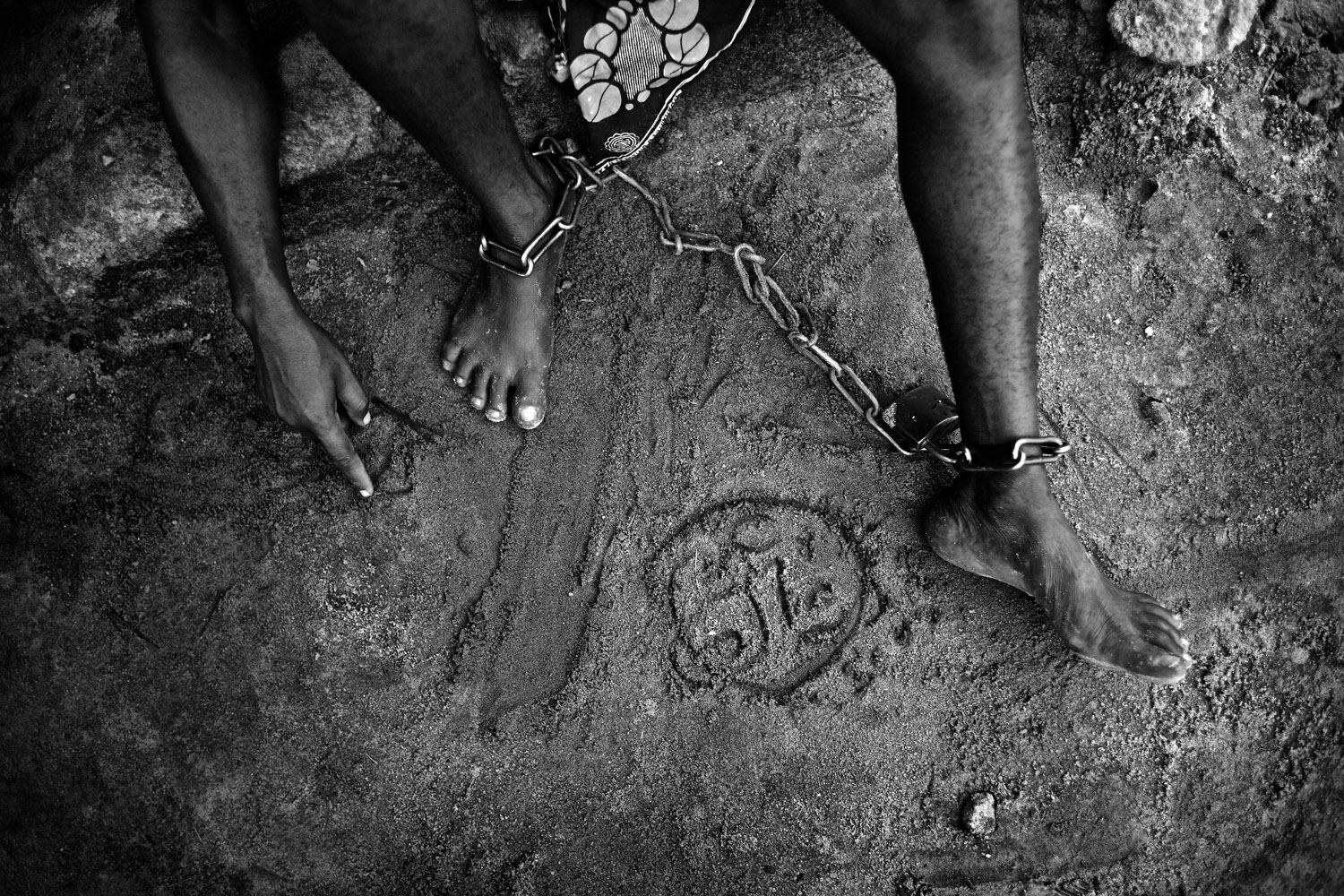Reverend Apostle S.B.Esanwi, Doctor of Divinity, treats people with mental illness with prayer and traditional medicines which usually consist of roots and leaves crushed in water. He claims to have cured hundreds of patients. Many stay for months in his compound. Some are chained throughout their time there. The Niger Delta, Nigeria. October 2012. Photo Robin Hammond/Panos