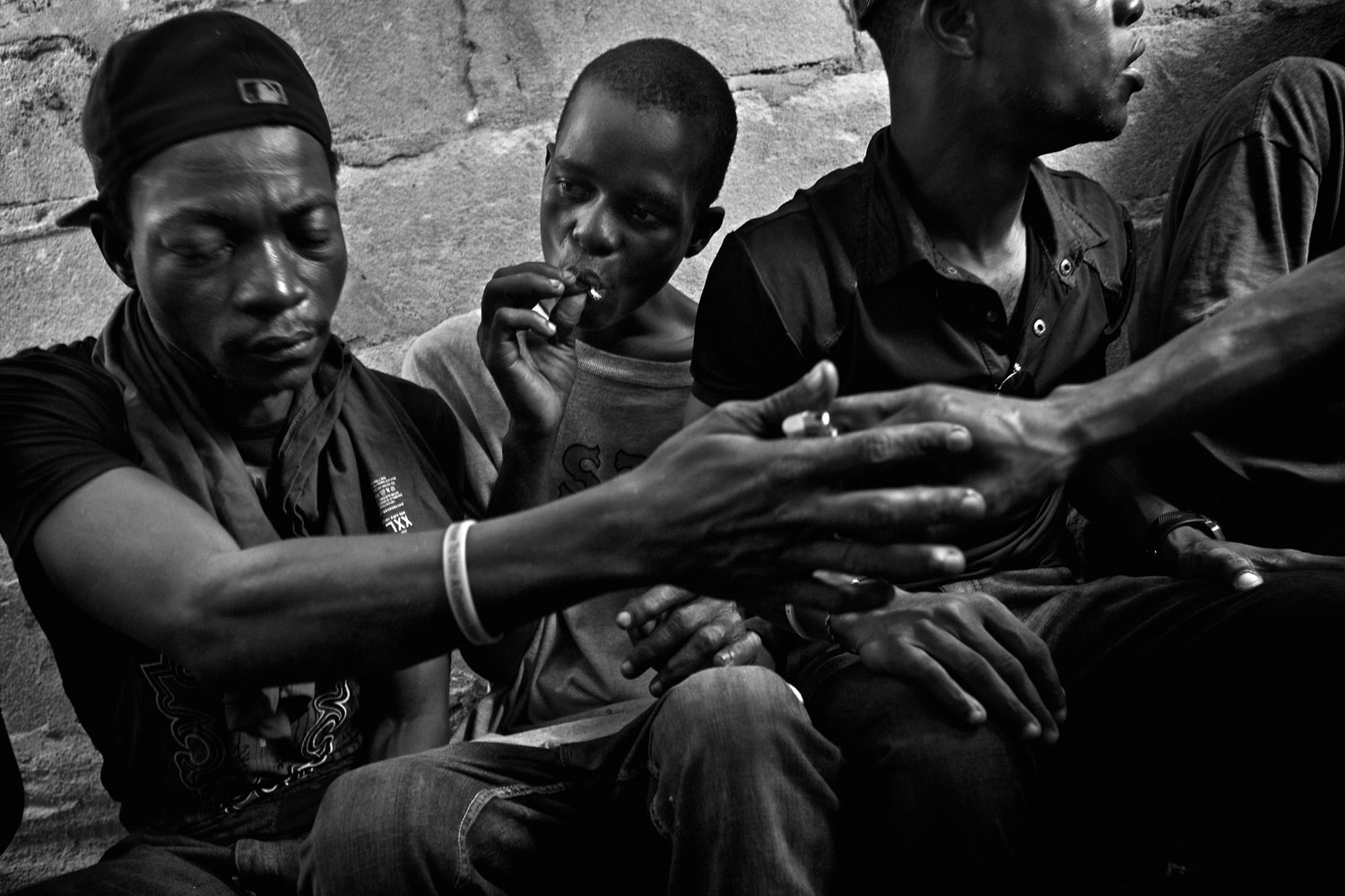 Former child soldiers smoke marijuana laced with heroin at the informal settlement known as Trench Town. Thousands of Liberia’s children were conscripted to fight in the country’s bloody civil wars between 1989 and 2003. Monrovia, Liberia. January 2013.