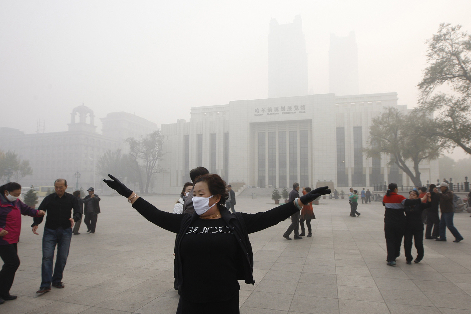 Oct. 21, 2013. Local residents dance on a square under heavy smog in Harbin, northeast China's Heilongjiang province.
