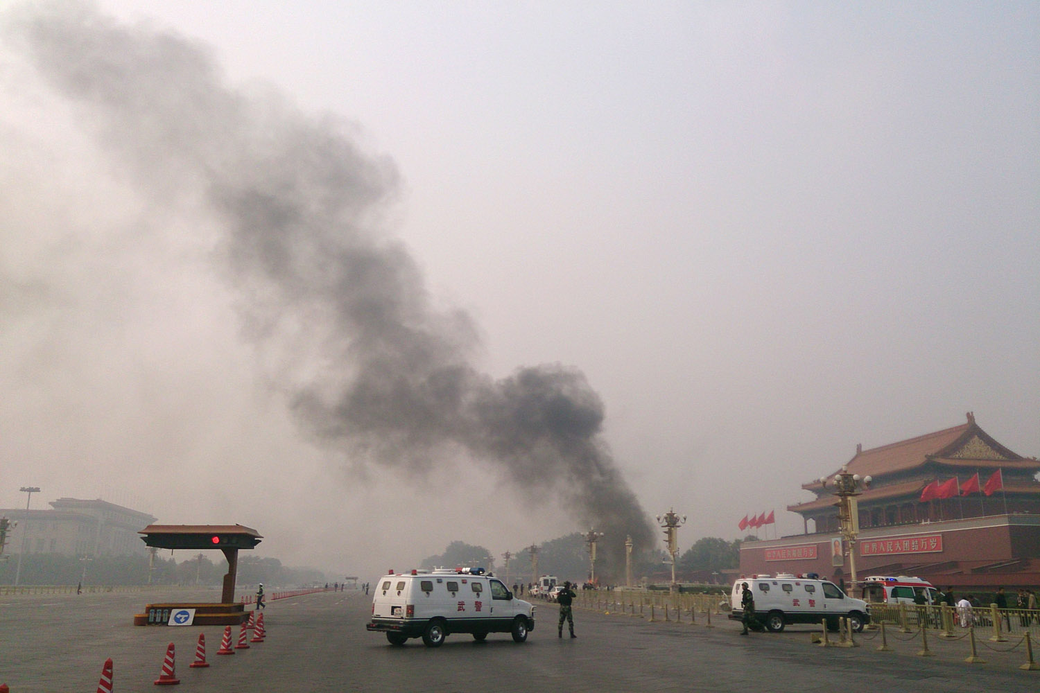 Oct. 28, 2013. Police cars block off the roads leading into Tiananmen Square as smoke rises into the air after a vehicle crashed, killing three people, in front of Tiananmen Gate in Beijing, China.