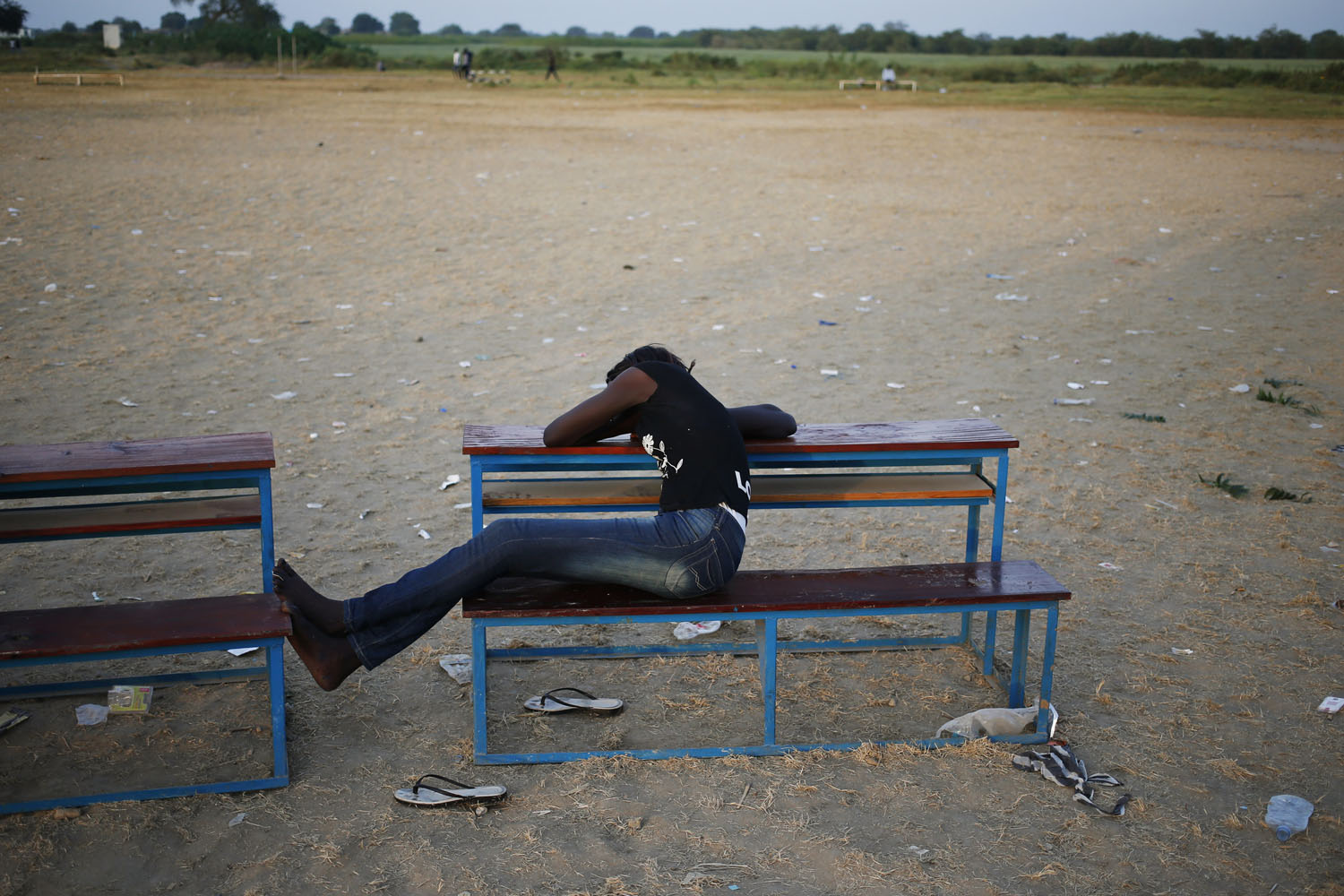 Woman sleeps as she waits to vote in front of a polling station in a school during a referendum in the town of Abyei