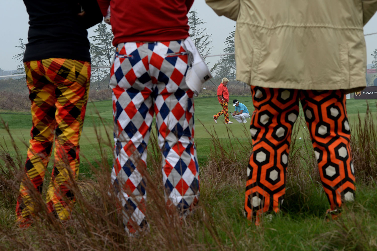 Oct. 24, 2013. John Daly of the US (back orange) is watched by his fans at the 7th hole during day one the BMW Shanghai Masters golf tournament at the Lake Malaren Golf Club in Shanghai.