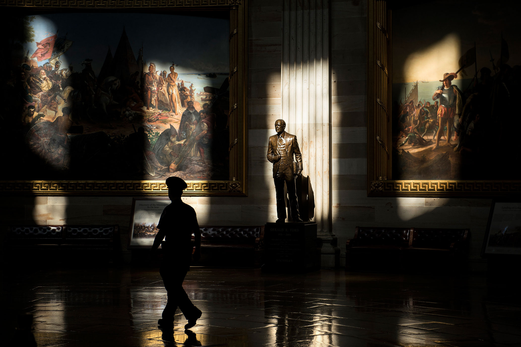 Oct. 1, 2013. A Capitol Police Officer walks past a statue of Gerald Ford, who was president during the 1976 shutdown of the federal government, in the Rotunda while the building was closed to tours on Capitol Hill in Washington.