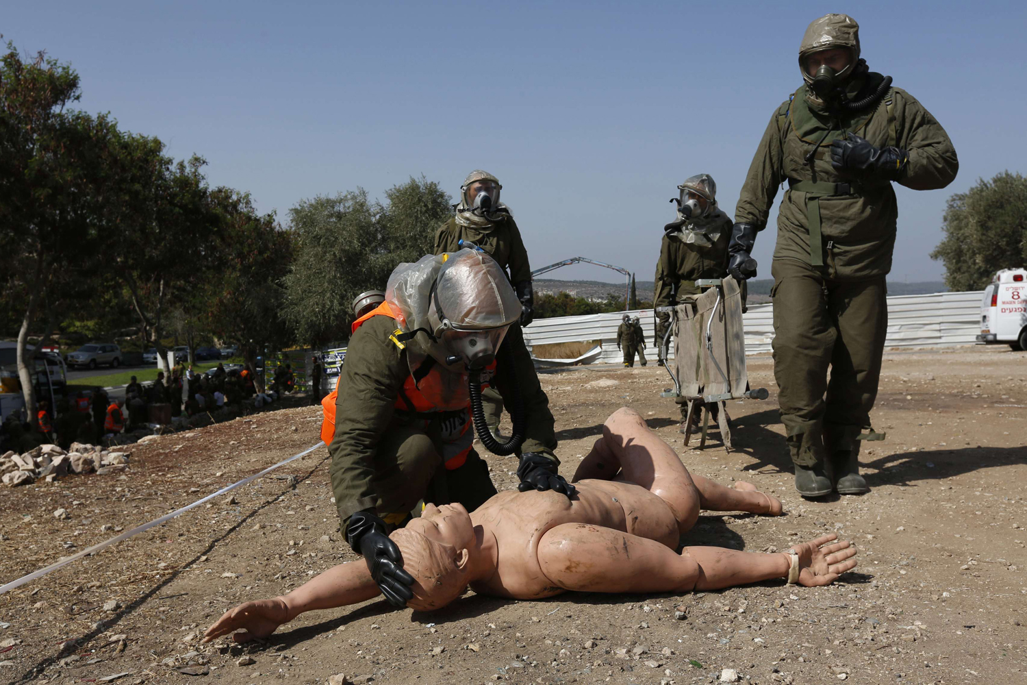 Oct. 2, 2013. An Israeli soldier from the home front command wearing protective gear kneels next to a dummy during a drill simulating a chemical attack in the town of Beit Shemesh, near Jerusalem.